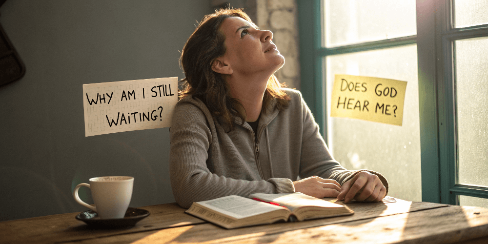 Christian woman sitting with Bible and coffee, looking upward with sticky notes asking 'Why am I still waiting?' and 'Does God hear me?' on window